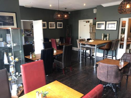 a restaurant with tables and chairs in a room at The Sunningdale in Bamburgh