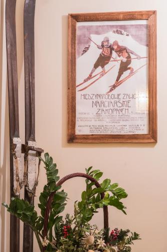 a picture hanging on a wall next to a plant at Willa Ryś in Zakopane