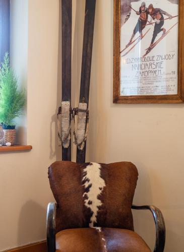 a chair in a room with skis on the wall at Willa Ryś in Zakopane