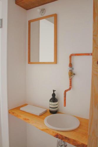 a bathroom with a sink and a mirror on a counter at WhyKumano in Nachikatsuura