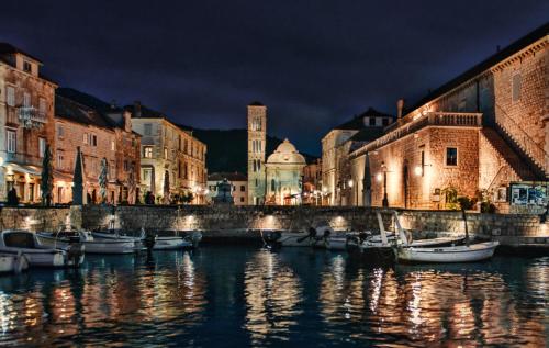 a group of boats docked in a canal at night at Apartments Villa Tudor in Hvar