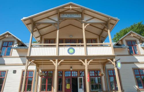 a large wooden building with a balcony on top at Ronneby Brunnspark Vandrarhem och B&B in Ronneby