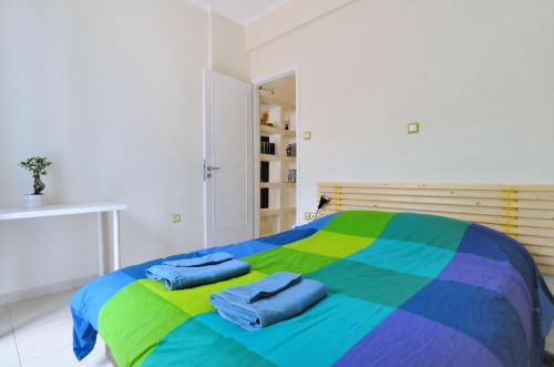 a colorful bed with two towels on top of it at Courtyard Apt - Central Athens in Athens