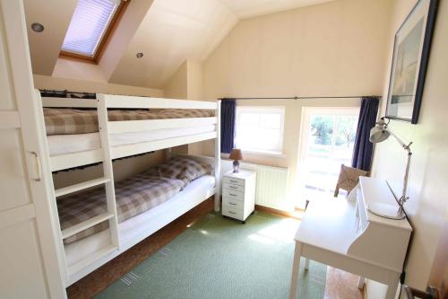 a bedroom with two bunk beds and a desk at Haus Eichenhain in Scheeßel