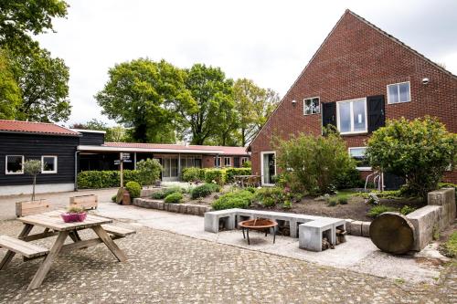 um pátio com uma mesa de piquenique e um edifício em De Johanneshoeve em Westerhaar-Vriezenveensewijk