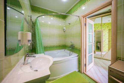 a bathroom with a tub and a sink and a mirror at Апартаменты на площади Ленина от ApartmentCity in Mogilev