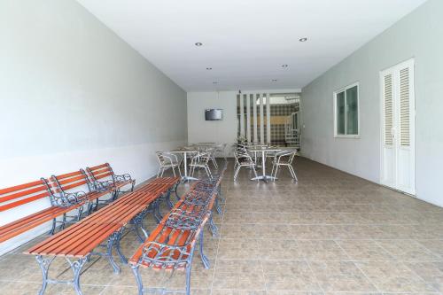 a room with benches and tables and chairs at HOME Guesthouse in Surabaya
