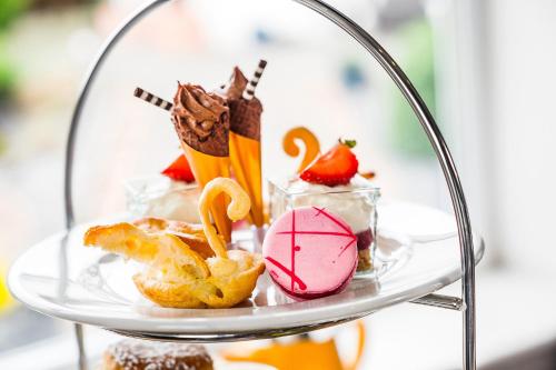 a glass plate with pastries and desserts on it at Llanerch Vineyard Hotel in Hensol