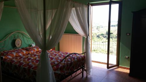 a bedroom with a bed with a canopy and a window at Domus Quarticelli Costa dei Trabocchi in Torino di Sangro