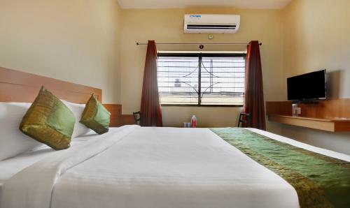 a bedroom with a large white bed and a window at Itsy Hotels KES Residency, 10 Min From KSR Bengaluru City Junction in Bengaluru