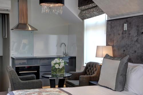a living room with a bed and a table with flowers at Best Western Chiswick Palace & Suites London in London