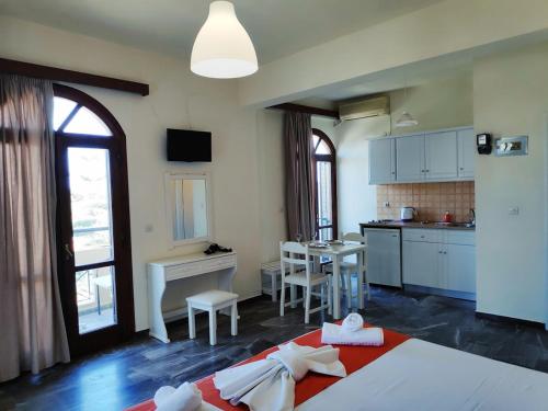 a room with a kitchen and a bed and a table at Creta Sun Studios in Kato Daratso