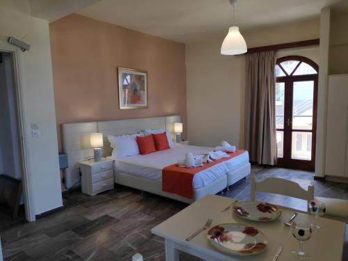a bedroom with a large bed with red pillows at Creta Sun Studios in Kato Daratso