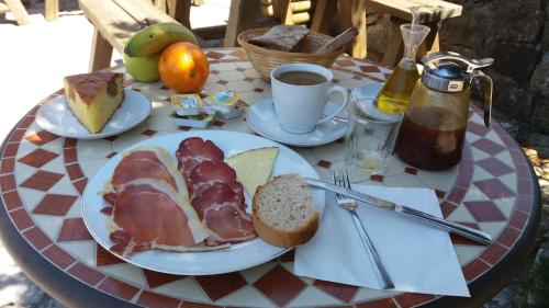 un tavolo con un piatto di cibo e una tazza di caffè di La Corona del Auteiro a Valle de Lago
