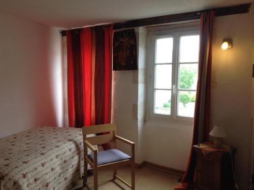a bedroom with a bed and a chair and a window at Chambre chez l'habitant au centre ville in La Flèche