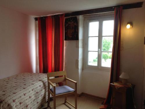 ein Schlafzimmer mit einem Bett und einem Stuhl und einem Fenster in der Unterkunft Chambre chez l'habitant au centre ville in La Flèche