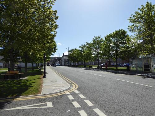 an empty street with trees on the side of the road at The Red Lion Tavern in Fochabers