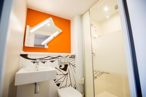 a bathroom with a sink and a mirror at ibis budget Cherbourg - La Glacerie in Cherbourg en Cotentin