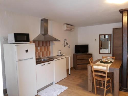 a kitchen with a white refrigerator and a table at Apartments Garden in Rovinj
