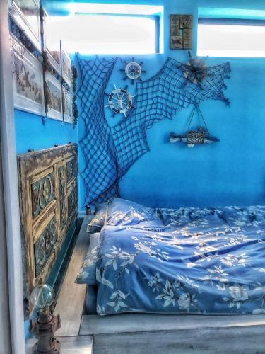 a blue bedroom with a bed and a blue wall at HemDem Alçıtepe in Canakkale