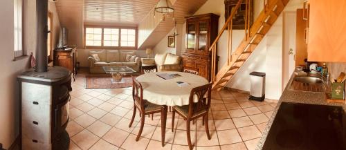 eine Küche und ein Wohnzimmer mit einem Tisch und Stühlen in der Unterkunft Paola paradise in Forel