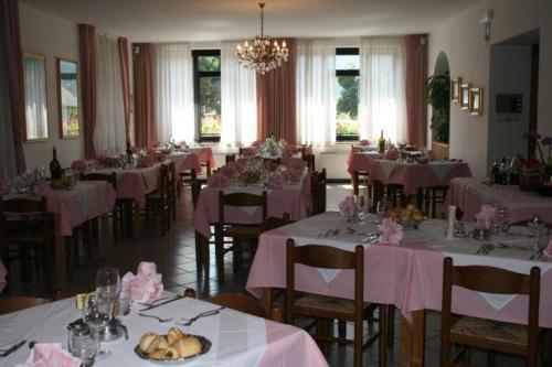 a dining room with tables with pink tablecloths at Hotel Milano in Folgaria