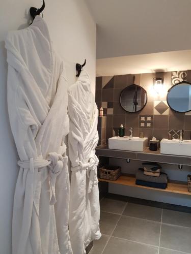 a bathroom with two white towels hanging on a wall at La Loge du Grand Cèdre, gîte de charme in Fontcouverte