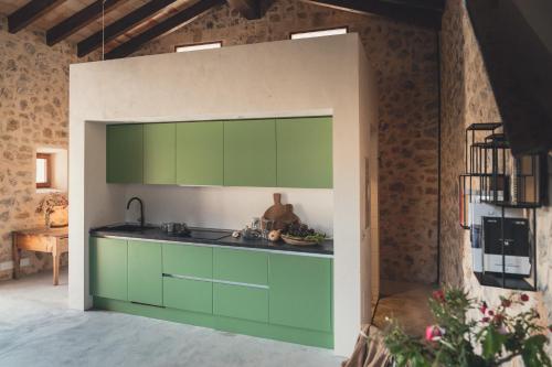 eine Küche mit grünen Schränken in einem Zimmer in der Unterkunft Son Mesquida Vell in Manacor