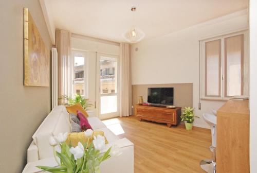 a living room with a white couch and a television at Suite Manin in Treviso