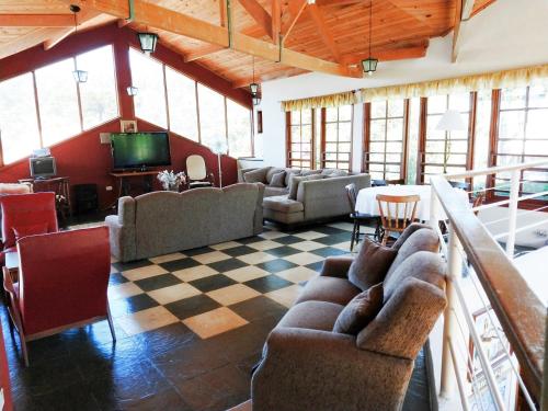 una gran sala de estar con sofás y TV. en Alpenhaus Pousada, en Campos do Jordão