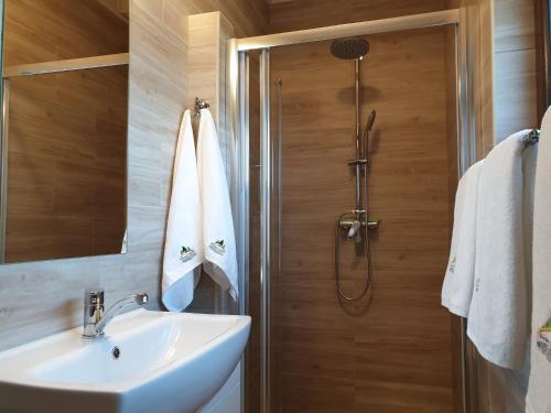 a bathroom with a sink and a shower at Kamienny Ogród Holiday Park in Mikołajki