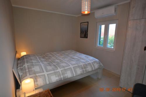 a bedroom with a bed and a window at Dreamlodge - Luxe Dalmatian Villa, private pool, parking, mooring, breathtaking sea & mountain view, at 150 m from idyllic private beach in Rogač