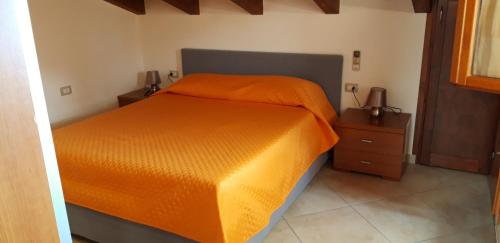 カステルサルドにあるSunset Viewのベッドルームにオレンジの掛け布団付きのベッド1台