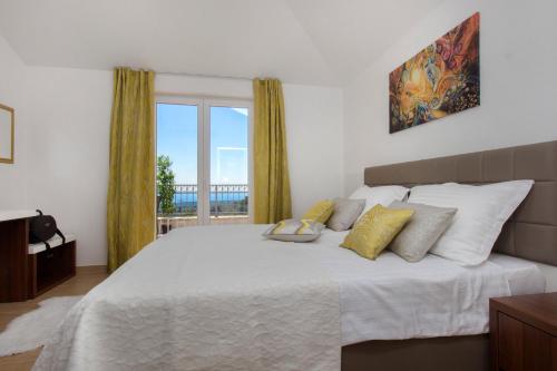 a bedroom with a large bed with a large window at Villa Terra Rogoznica in Rogoznica