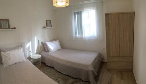 a bedroom with two beds and a window at Apartment Laoura in Corfu Town