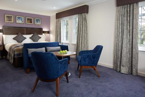 a hotel room with a bed and a table and chairs at The Bull in Gerrards Cross