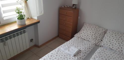 een slaapkamer met een bed met een kussen en een dressoir bij Apartament Aga2 in Oświęcim
