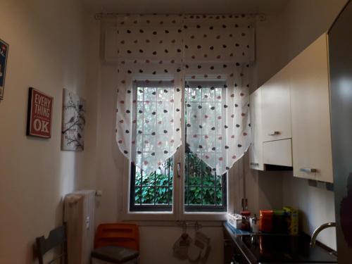 a kitchen with a window with polka dot curtains at La casa di Laura in Bologna
