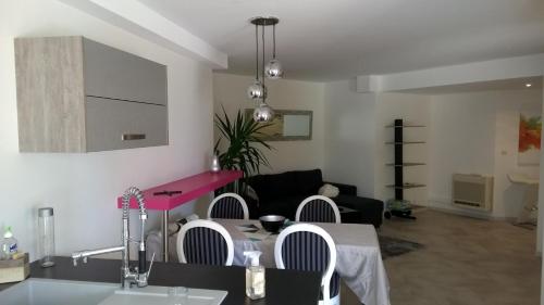 a kitchen and living room with a table and chairs at Le Mas de Chartreuse in Miribel-les-Échelles
