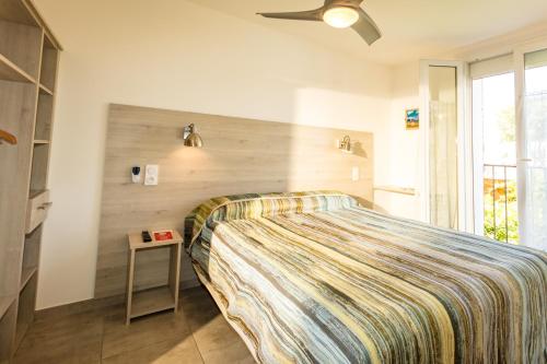 a bedroom with a bed with a wooden wall at Auberge du Bon Vivant in Argelès-sur-Mer