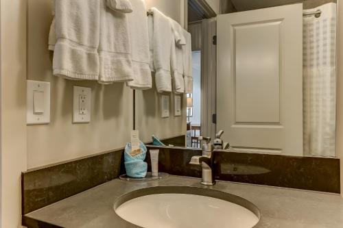 a bathroom with a sink and a mirror and towels at Beachside Motel - Amelia Island in Amelia Island