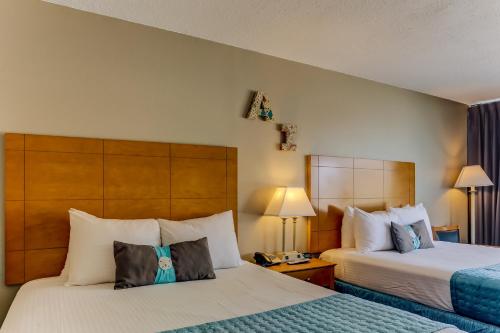 a hotel room with two beds and two lamps at Beachside Motel - Amelia Island in Amelia Island
