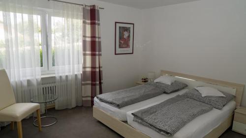 1 dormitorio con 1 cama, 1 silla y 1 ventana en Ferienwohnung Bucher Ursula, en Waldmünchen