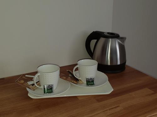 a tray with two coffee cups and a tea kettle at la blanchetière in Francueil