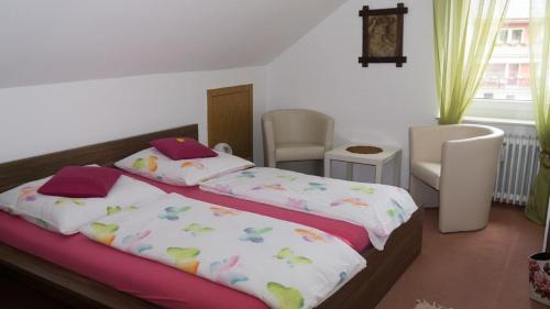 a bedroom with a bed and two chairs at Ferienwohnung Bucher Ursula in Waldmünchen
