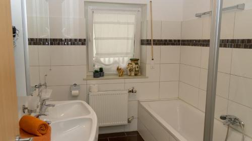a white bathroom with a sink and a bath tub at Ferienwohnung Bucher Ursula in Waldmünchen