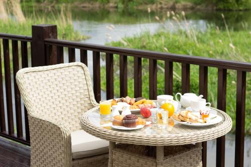 a table with a tray of breakfast food on a balcony at The Bridge House; BW Signature Collection in Ferndown