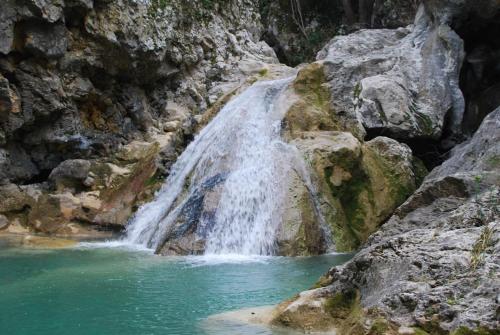 a waterfall on the side of a rocky mountain at Olivenhuset in Fons-sur-Lussan