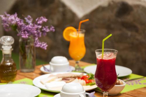 a table with a plate of food and two drinks at Gioma Hotel in Agia Galini