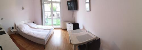 a bedroom with a bed and a desk and a window at Apartament Trzy Korony 1 in Świnoujście